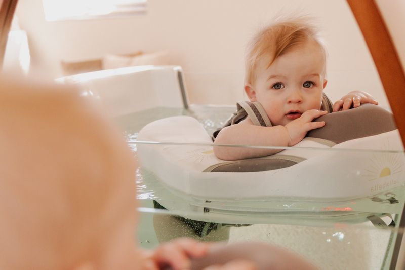 Foto (ellabella): een baby met zwemring in het babybad